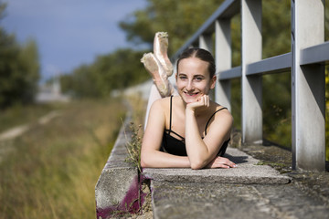 Young ballerina laying at a handrail