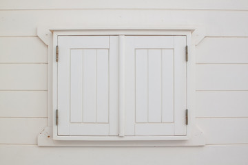 White wooden shutters closed window.