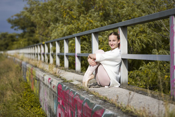 Young Ballerina sitting at a handrail outdoor