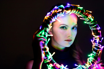 Young caucasian woman lighted up by illumination ring.
