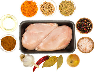 Fresh raw chicken breast with spices on white background