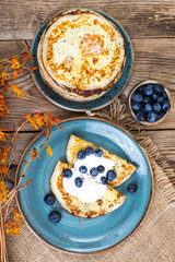 American pancakes with sauce and blueberries on wooden table top