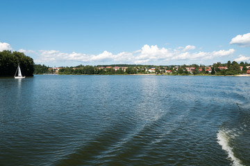 Obraz premium Small town or village in distance behind the lake