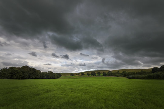 Dark clouds over green rural countryside England