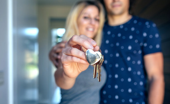 Happy couple showing the keys of their new house
