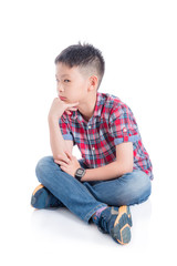 Unhappy asian boy sitting on the floor over white background