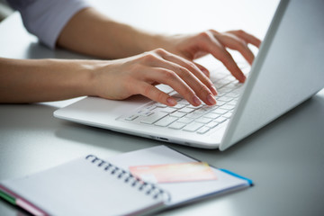 Businesswoman typing on a laptop.