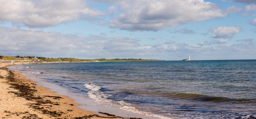 Panorama of Whitley Bay beach with a lighthouse on the island, England