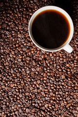 Coffee cup on coffee beans in close up photo. Refreshing beverage in the morning