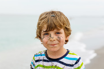 Little kid boy having fun on tropical beach