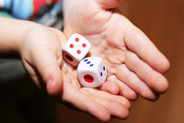 A hand with a pair of dice