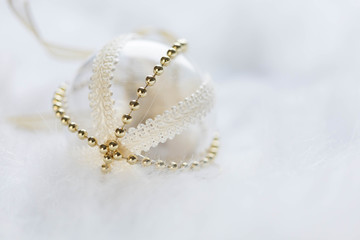 Gold Christmas baubles on white fur. Festive winter concept.
