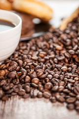 Croissant and coffee beans in close up photo. Delicious morning drink and snack