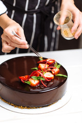 Female hands decorating cake