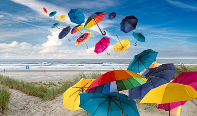 Vacation on the sea, lust for life: flying colorful umbrellas  in front of blue sky with clouds:)
