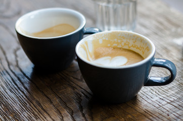 two cups of coffee on a wooden table