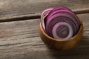 Onion slices in wooden bowl