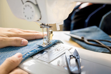 Close up of tailor's hand working with sewing machine