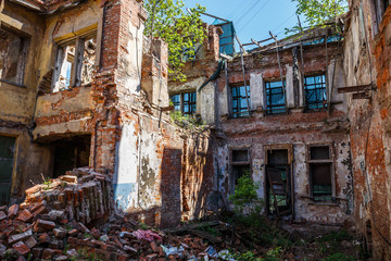 Fototapeta na wymiar Old abandoned red brick house ruin, damaged by earthquake, war or other natural disaster, demolished decay debris