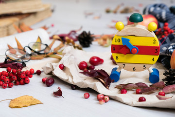 Fall Time Alarm clock on a rustic wooden table with colorful Autumn leaves. with light shadow and shallow depth of field. Daylight savings time concept. Autumn Time Change, with copy space. Top view