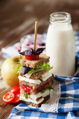 Healthy school lunch with a sandwich, fresh fruits, bun and milk