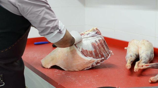 Cutting of the lamb for the preparation of meals. Butcher cut up the carcass of fresh meat.