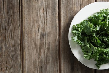 Kale vegetable in plate on wooden table