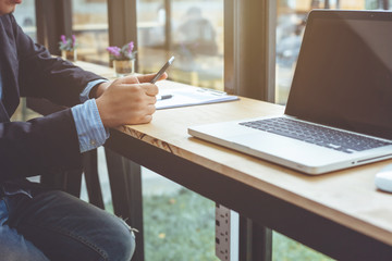 young man working using smart phone and notebook computer