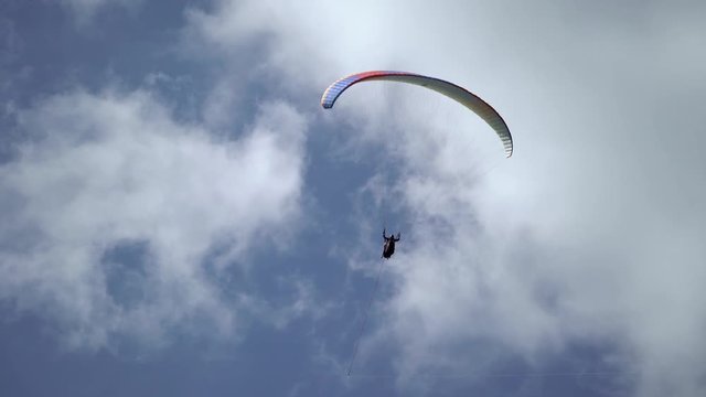 Paraglider flying in the sky at sunny day