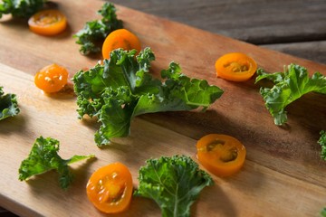Close up of kale and tomato slices on cutting board