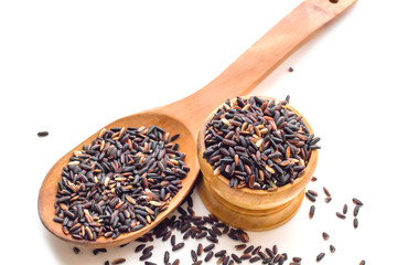 Rice berry or uncooked brown rice in wood bowl on white background, Thai black jasmine rice or Rice berry with white background.