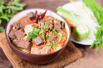 Northern Thai food (Kanom Jeen Nam Ngeaw) with vegetables on wooden background,spicy rice noodles soup,rice vermicelli served with curry