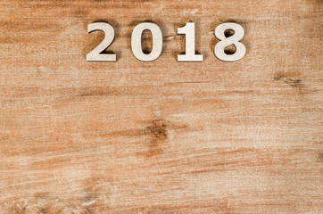 Sign 2018 from wooden letters, symbol of wooden texture background. Happy new year 2018 on wooden rough background. Greeting card.