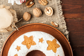 homemade traditional fruit cake on clay plate decorated with and nuts at wooden table top view