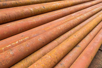 rusty metal tubes and pipes for construction and industrial use laying on heap