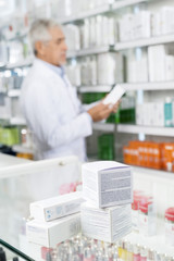Boxes On Counter With Chemist Working In Pharmacy
