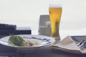 mug of beer with a nice salad with cheese and ham are on the table in a cafe