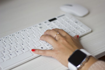 Female hands typing on white computer keyboard