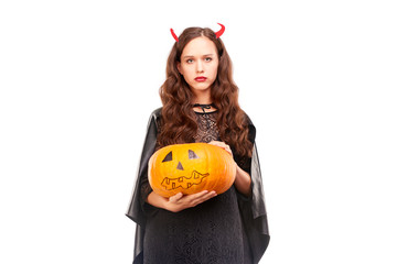 Young woman in Halloween costume posing against white background in studio