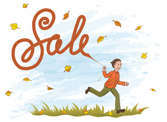 Joyful boy running on the grass with kite like lettering Sale. Yellow and orange leaves in the blue sky.