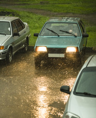 The person is sitting in the car during heavy rain. Heavy rain interferes with traffic..