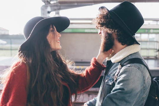 Young couple outdoors, face to face, young woman touching man's face