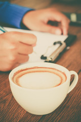 hand writing with cup of coffee