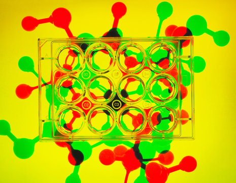Photogram. Multiwell plates containing samples, molecular model of drug formula in background to illustrate ground breaking pharmaceutical research