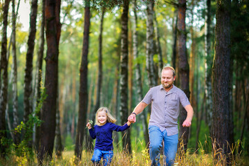 Fototapeta premium dad walks in the park with his beloved daughter, run and have fun