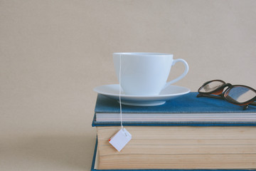 Book glasses and tea on the desk with study and education concept