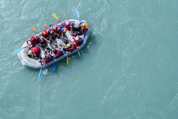 Top view of the boat with people rafting along the mountain river - obrazy, fototapety, plakaty