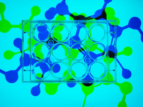 Photogram. Multiwell plates containing samples, molecular model of drug formula in background to illustrate ground breaking pharmaceutical research