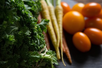 Mustard greens, carrots and tomatoes on tray