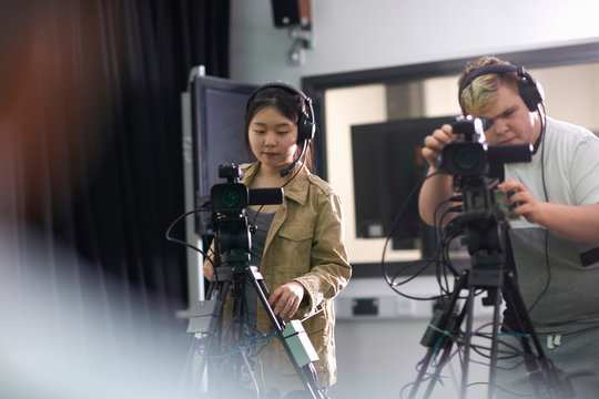 Over shoulder view of college students filming in TV studio